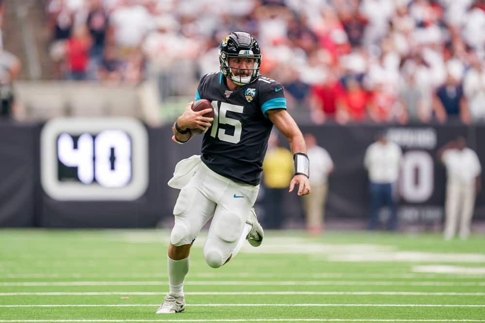 Jacksonville Jaguars quarterback Gardner Minshew (15) runs the ball during a football game. Can he inspire the Jaguars to victory? Our betting pick says he will.